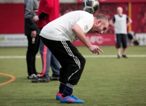 A participant balances the football on his neck