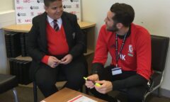 Stepping Up coach help a pupil with their learning