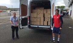 M F C Foundation's Ollie helps load a van with crisps