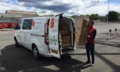M F C Foundation's Dan helps load a van with crisps